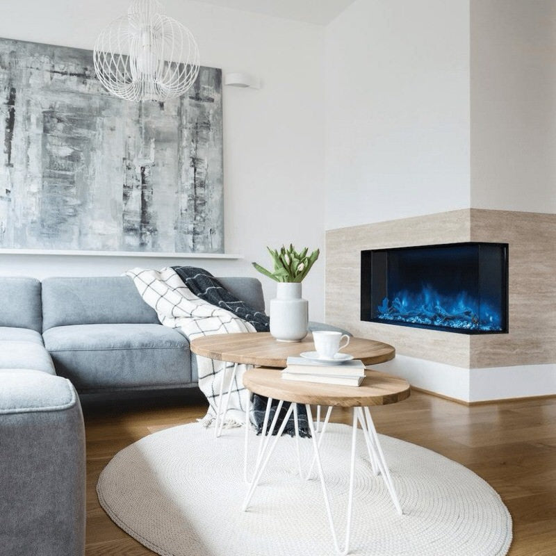 modern flames landscape pro multi 3 sided smart electric fireplace installed in a contemporary living room with blue flames and wall art