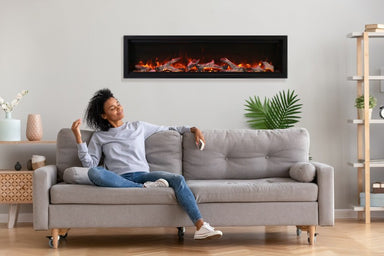 amantii symmetry bespoke 74-inch wall-mount/recessed electric fireplace installed in living room with woman sitting on couch